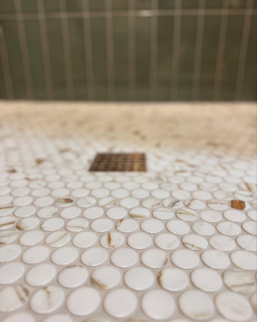 Close-up view of penny tiles and new professionally installed drain