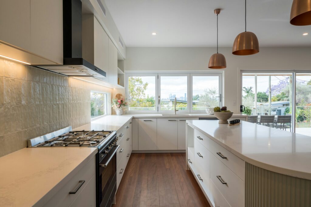 Renovated kitchen with sage green tile accents. central island with pendant lighting over it. The best home remodeling in Winston-Salem