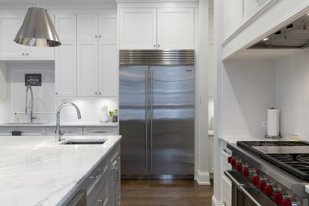 renovated kitchen with a whiter marble island and modern appliances