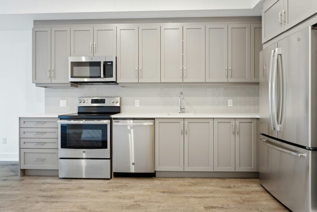 Kitchen remodeling in Winston-Salem. New, beige-colored cabinets in an L-shape with modern appliances installed